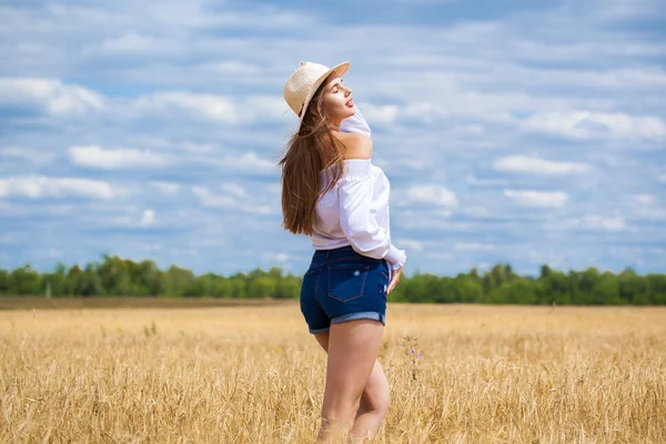 Mladá brunetka v bílé košili a modré džíny — Stock fotografie