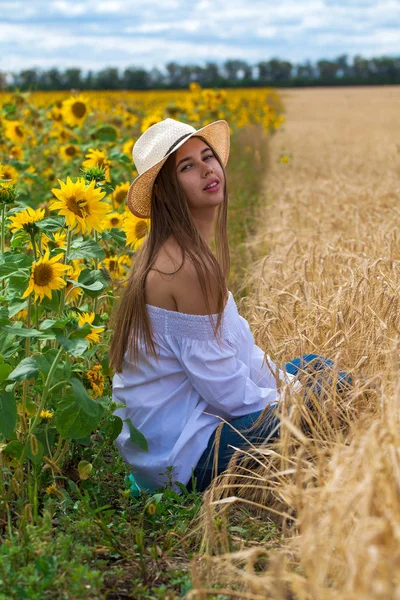 Mujer morena en blusa blanca sentada sobre un fondo de oro — Foto de Stock