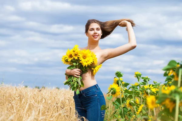 Menina sexy com um buquê de girassóis posando em um backgro campo — Fotografia de Stock