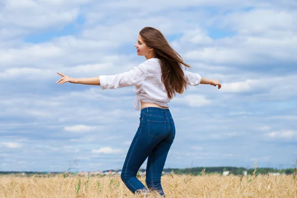 Young brunette woman in white shirt and blue jeans — Stock Photo, Image