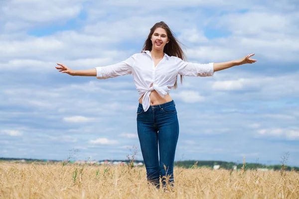 Mujer morena joven en camisa blanca y pantalones vaqueros azules — Foto de Stock