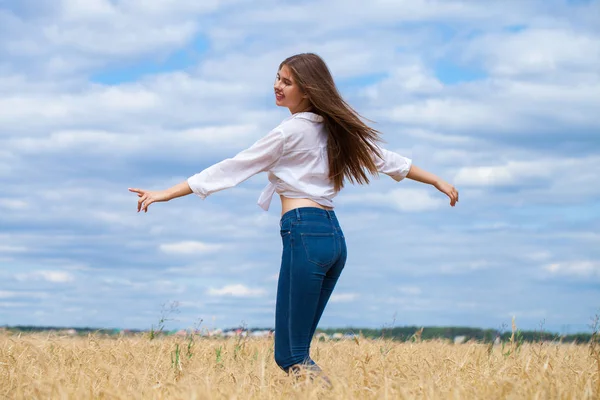 Young brunette woman in white shirt and blue jeans — Stock Photo, Image
