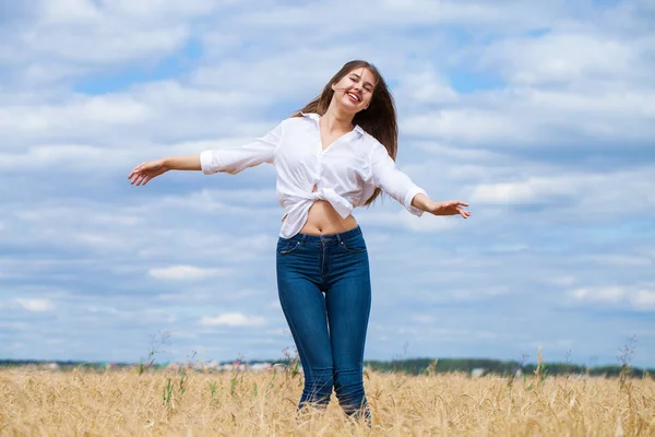 Mujer morena joven en camisa blanca y pantalones vaqueros azules — Foto de Stock