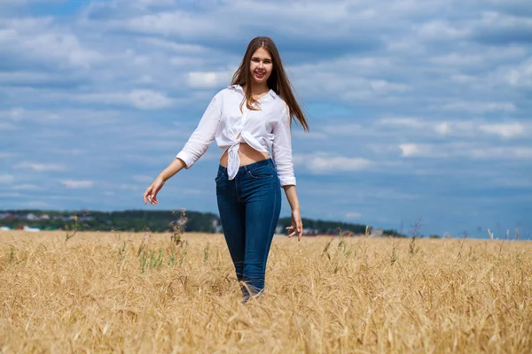 Junge brünette Frau in weißem Hemd und blauer Jeanshose — Stockfoto