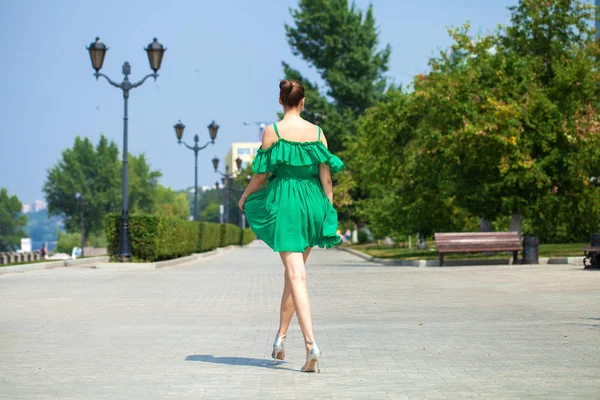 Νέα όμορφη μελαχρινή κορίτσι σε πράσινο φόρεμα περπατάει κατά μήκος του EMB — Φωτογραφία Αρχείου