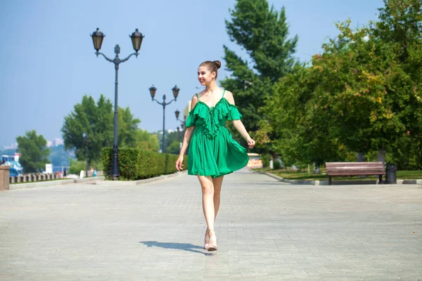 Jovem linda menina morena em vestido verde caminha ao longo do emb — Fotografia de Stock