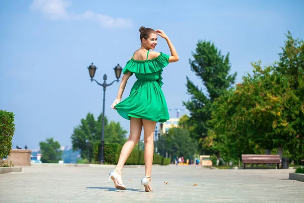 Yeşil elbise yaz yürüyüş üzerinde genç güzel kadın Stree — Stok fotoğraf