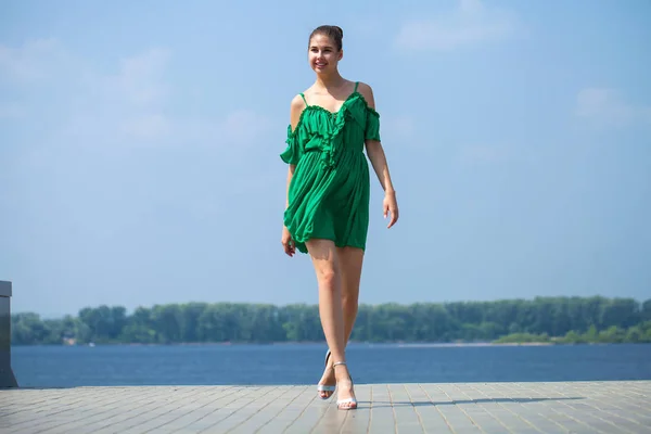 Молодая красивая брюнетка в зеленом платье прогулки по Эмб — стоковое фото