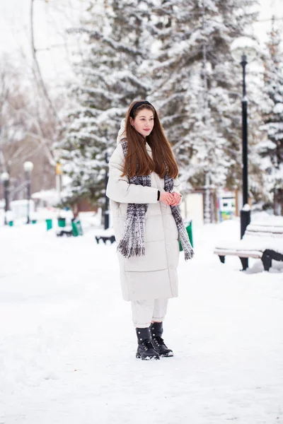 Young brunette woman in white down jacket in winter street — Stock Photo, Image