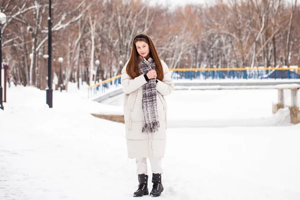 Молода брюнетка в білому піджаку на зимовій вулиці — стокове фото