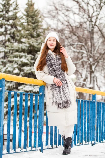 Young brunette woman in white down jacket in winter street — Stock Photo, Image