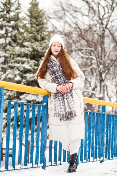 Young brunette woman in white down jacket in winter street — Stock Photo, Image
