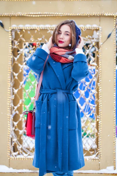 Happy young girl in blue coat posing in winter street — 스톡 사진