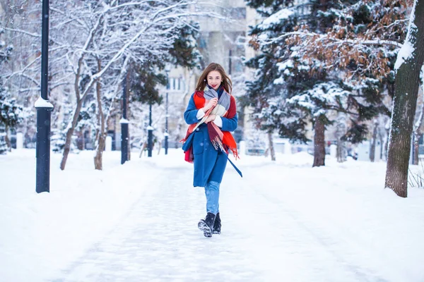 Gelukkig jong meisje in blauw jas poseren in winter straat — Stockfoto