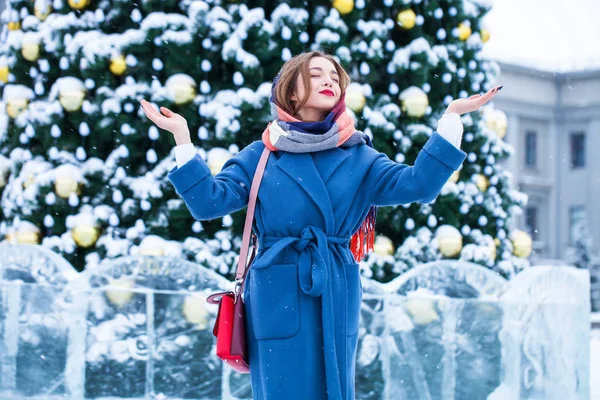 Happy young girl in blue coat posing in winter street — 스톡 사진
