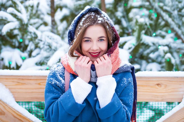 Glückliches junges Mädchen in blauem Mantel posiert in der Winterstraße — Stockfoto