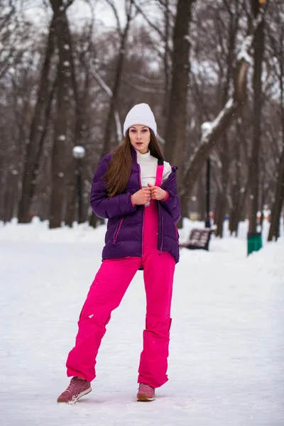 Portrait of a young beautiful woman in a ski suit posing in wint — Stock Photo, Image