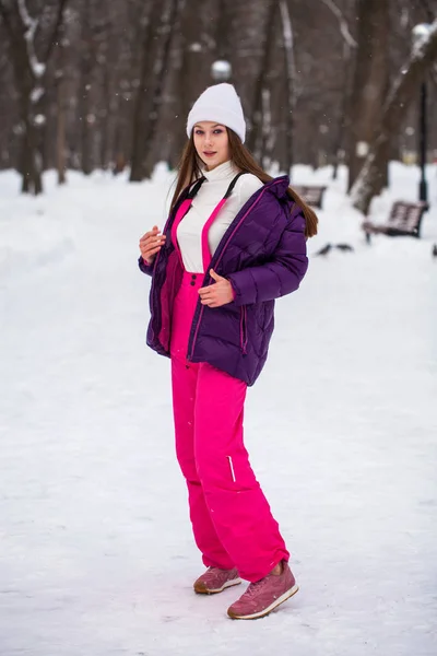 Portrait of a young beautiful woman in a ski suit posing in wint — Stock Photo, Image