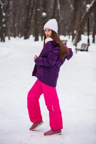 Portrait of a young beautiful woman in a ski suit posing in wint — Stock Photo, Image