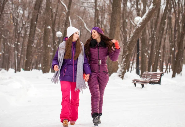 Due belle ragazze felici passeggiano in inverno in una città par — Foto Stock