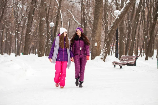 二つの幸せな美しい彼女は冬に街のパーで歩く — ストック写真
