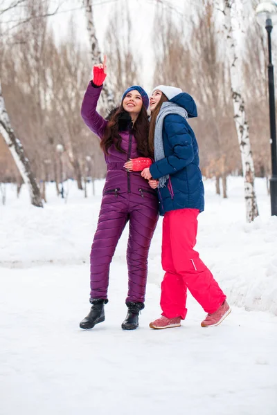 Портрет двух молодых красивых женщин в лыжном костюме, позирующих зимой — стоковое фото