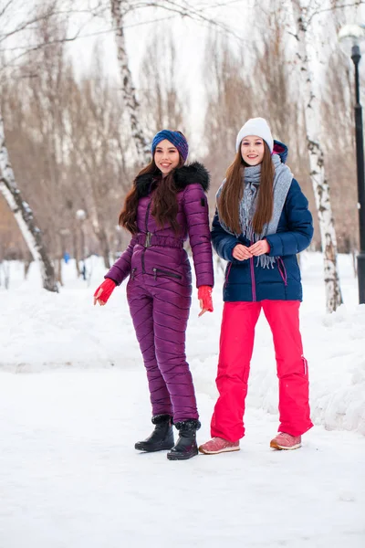 Retrato de dos mujeres jóvenes y hermosas en traje de esquí posando en invierno — Foto de Stock