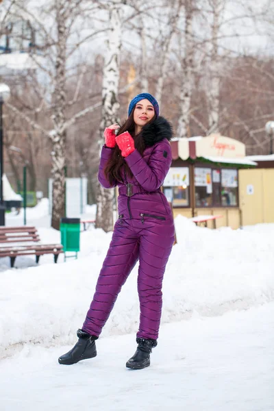 Portrait of a young beautiful woman in a ski suit posing in wint — Stock Photo, Image