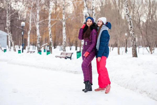 Retrato de dos mujeres jóvenes y hermosas en traje de esquí posando en invierno —  Fotos de Stock