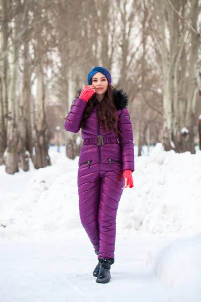 Retrato de una joven mujer hermosa en un traje de esquí posando en invierno — Foto de Stock