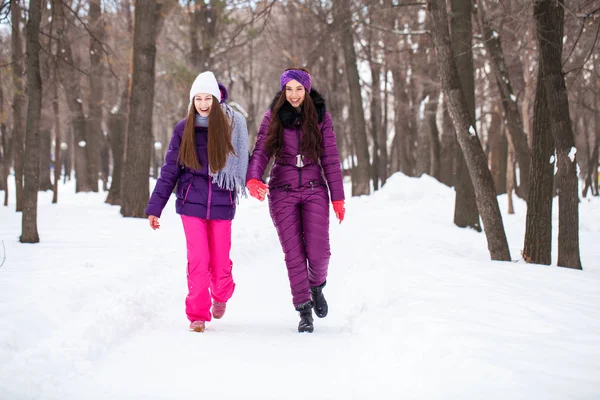 Deux jolies petites amies se promènent en hiver dans une ville par — Photo