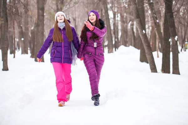 Deux jolies petites amies se promènent en hiver dans une ville par — Photo