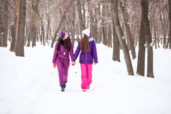 Due belle ragazze felici passeggiano in inverno in una città par — Foto Stock