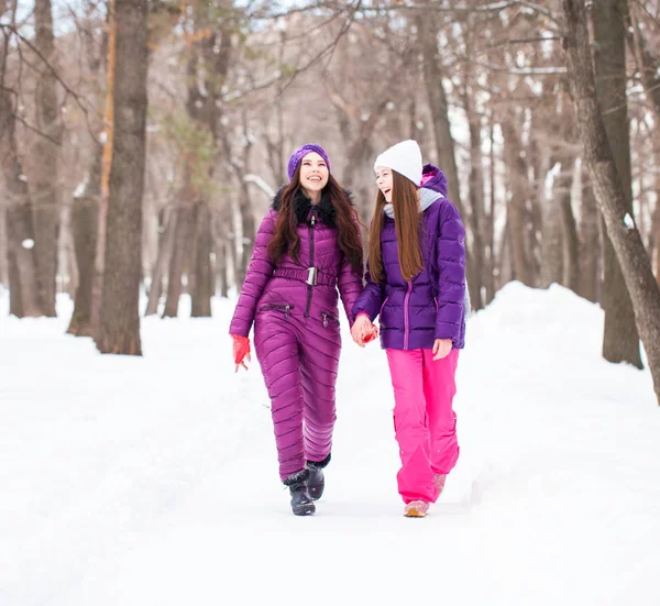 Due belle ragazze felici passeggiano in inverno in una città par — Foto Stock