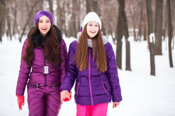 Due belle ragazze felici passeggiano in inverno in una città par — Foto Stock