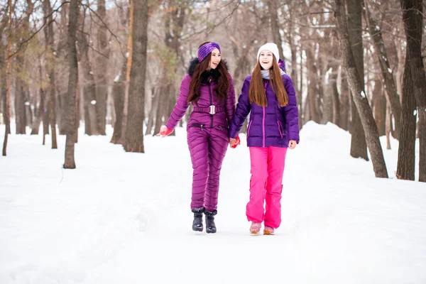 Deux jolies petites amies se promènent en hiver dans une ville par — Photo