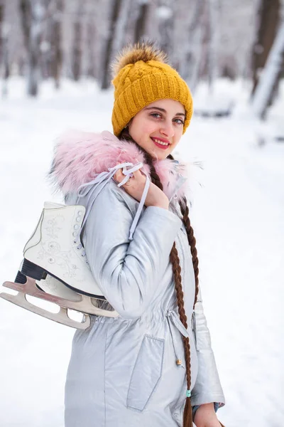 Happy beautiful brunette woman with ice skates go to the rink, w — 스톡 사진