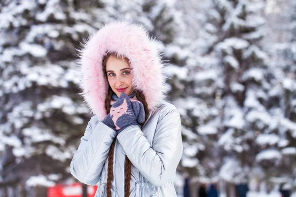 Young blonde woman in blue down jacket in winter street — Stock Photo, Image
