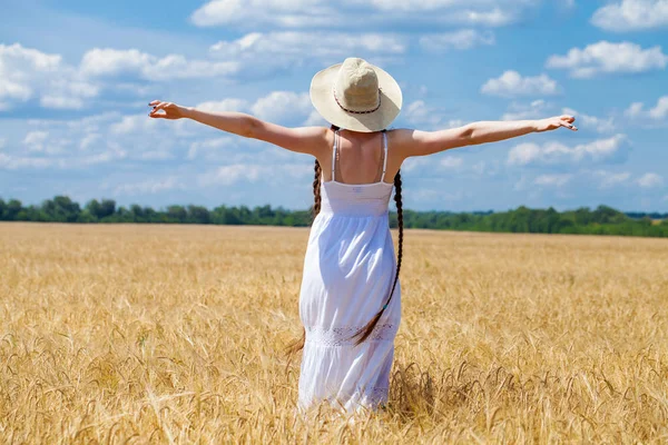 Mujer joven en vestido blanco posando contra el cielo azul en un lugar — Foto de Stock