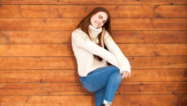 Mladý krásný teenager dívka pózovat na dřevěné zdi pozadí — Stock fotografie