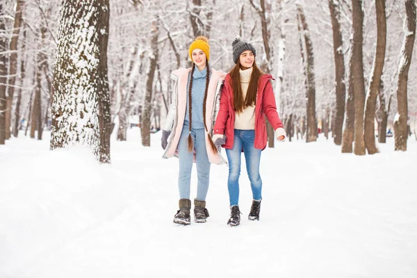 Portret dwóch młodych pięknych kobiet spacerujących w zimowym parku — Zdjęcie stockowe