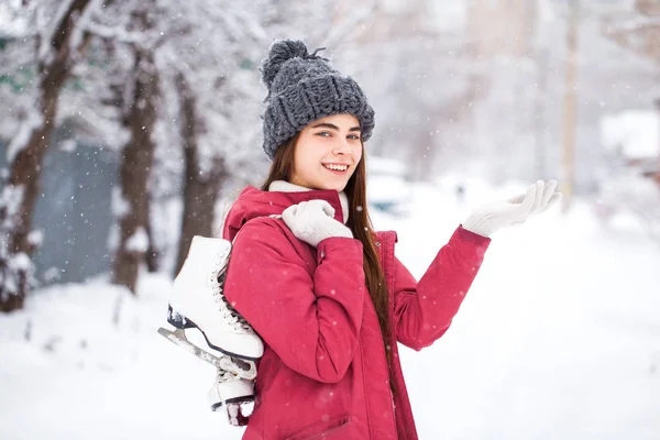 Gelukkig mooi brunette vrouw met schaatsen ga naar de ijsbaan, w — Stockfoto