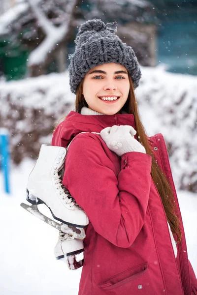 Gelukkig mooi brunette vrouw met schaatsen ga naar de ijsbaan, w — Stockfoto