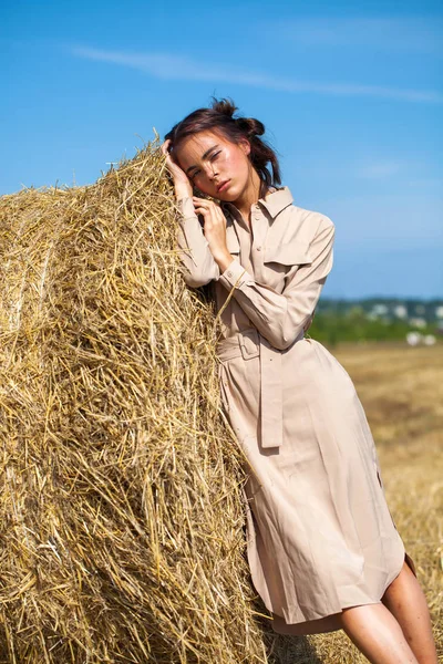 Gadis cantik dalam gaun krem berpose di latar belakang haysta — Stok Foto