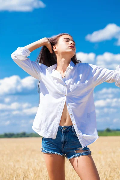 Giovane donna bruna in camicia bianca e pantaloncini blu jeans — Foto Stock