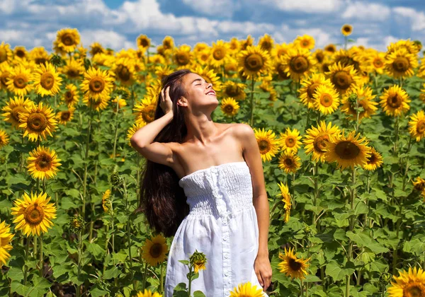 Retrato de una joven hermosa en un campo de girasoles — Foto de Stock