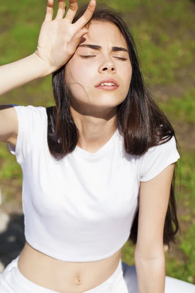 夏の公園に対してポーズ美しいブルネットの女性、明るい太陽 — ストック写真