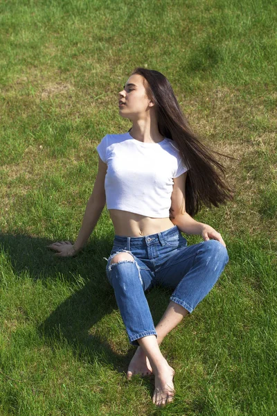 Retrato de uma jovem menina bonita descansando no gramado no pa — Fotografia de Stock