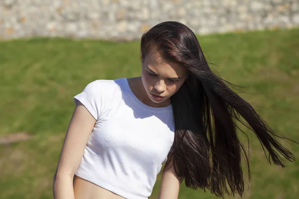 Joven hermosa adolescente posando contra el parque de verano, brillante —  Fotos de Stock