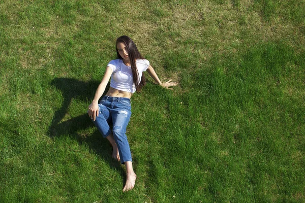 Muotokuva nuori kaunis tyttö lepää nurmikolla pa — kuvapankkivalokuva